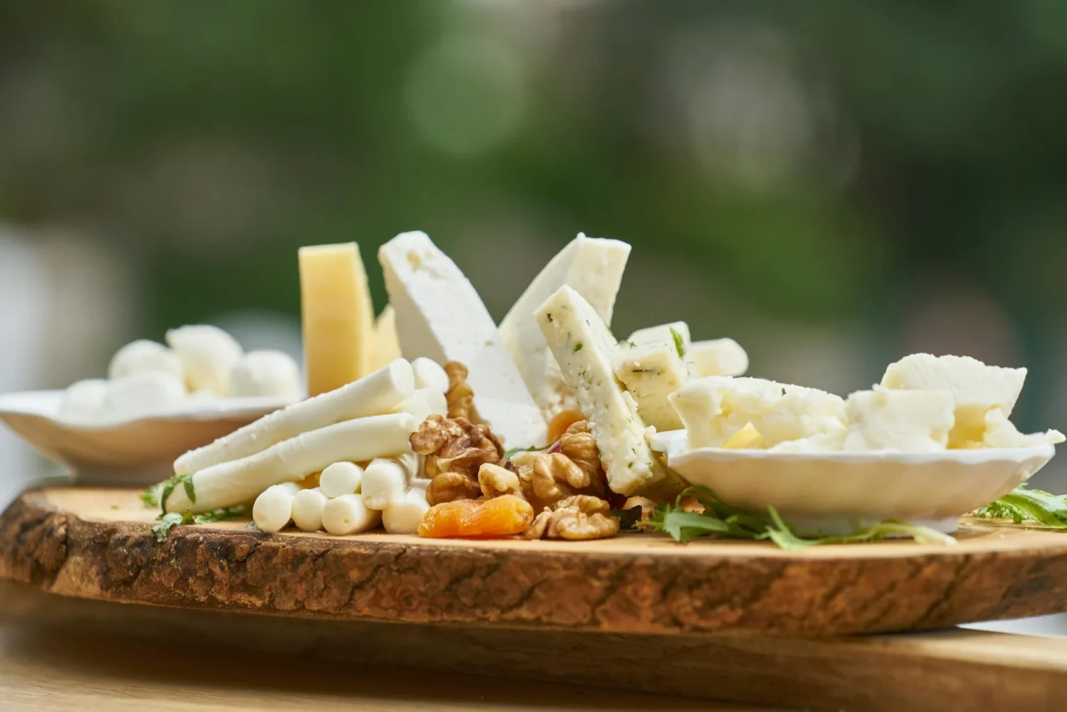 Wooden plate full of different kind of cheeses